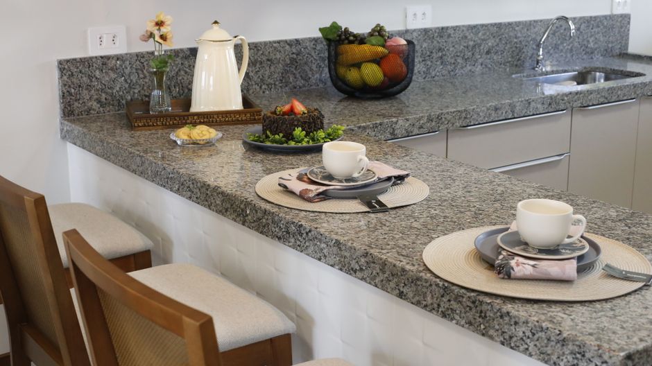 Kitchen counter with a cake and cups set out on a light countertop.